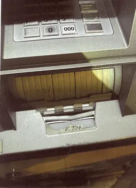 Fragment bankomatu z klawiaturą i szczeliną do wydawania banknotów.